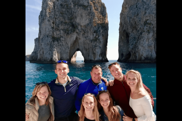 a group of people posing in front of a body of water