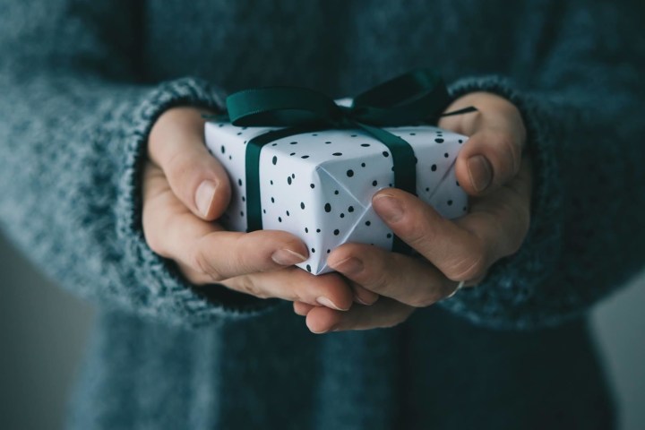 a hand holding a video game remote control