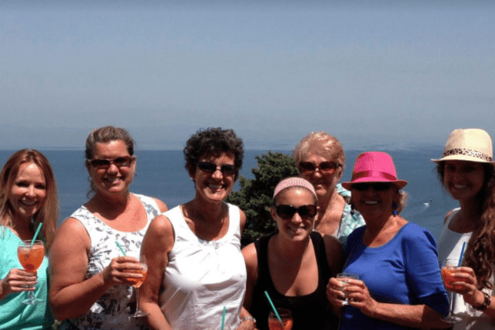 a group of people standing next to a body of water