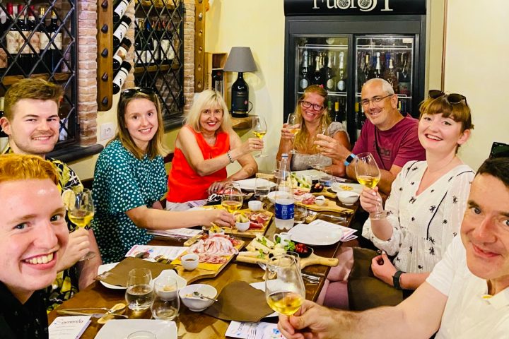 a group of people sitting at a dinner table posing for the camera