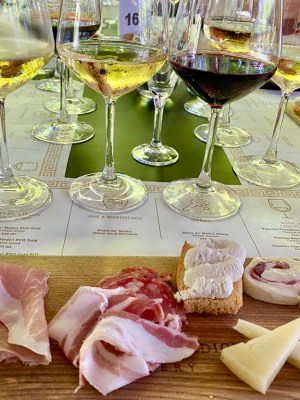 a person sitting at a table with food and wine glasses